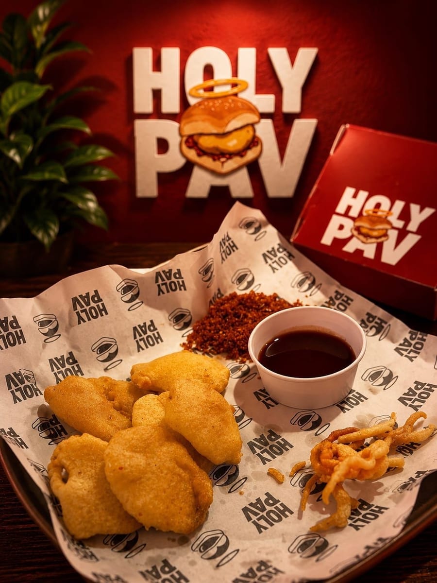 Kanda Bhajji fritters served with dry chutney and sweet tamarind chutney in a Holy Pav wrapper